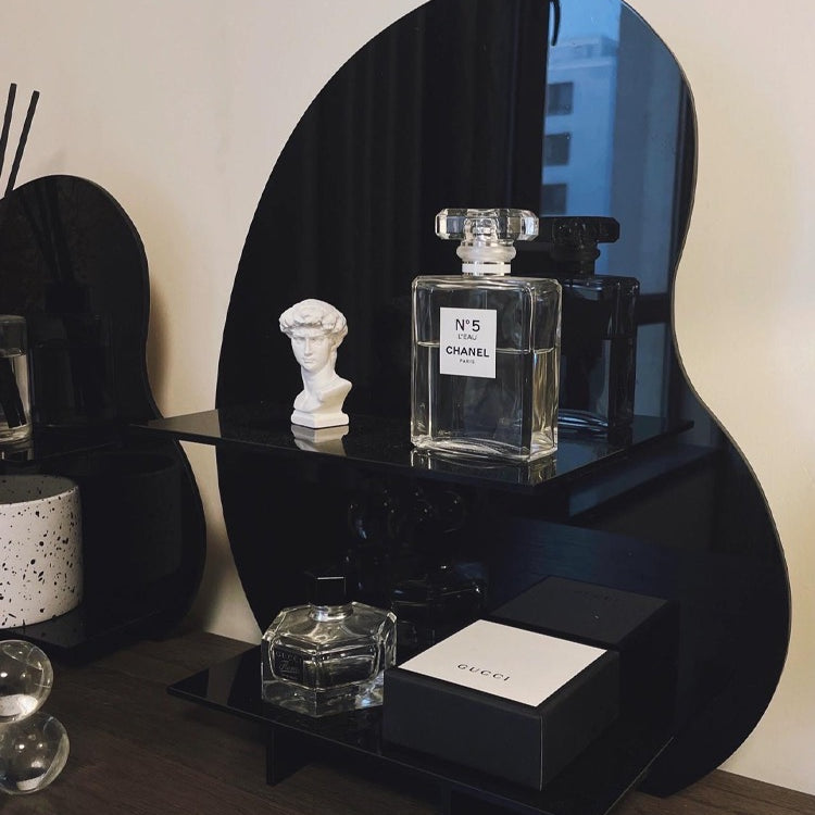 Acrylic Desktop Organizer in black displaying Chanel and Gucci perfumes on a wooden vanity