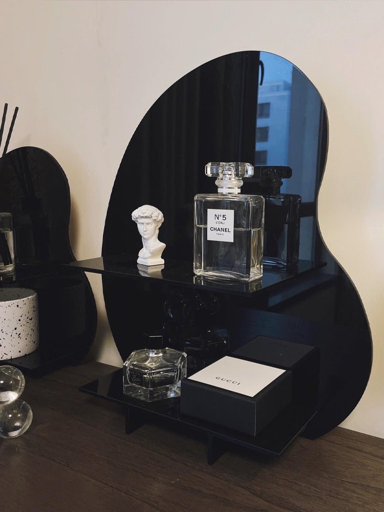 Acrylic Desktop Organizer in black displaying Chanel and Gucci perfumes on a wooden vanity