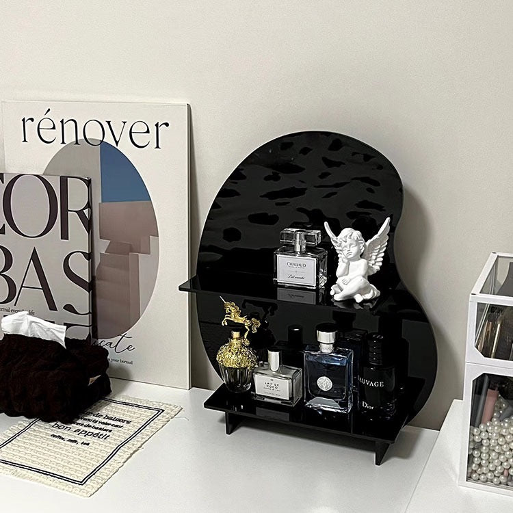 Acrylic Desktop Organizer in black holding perfumes and a small angel figurine on a white vanity