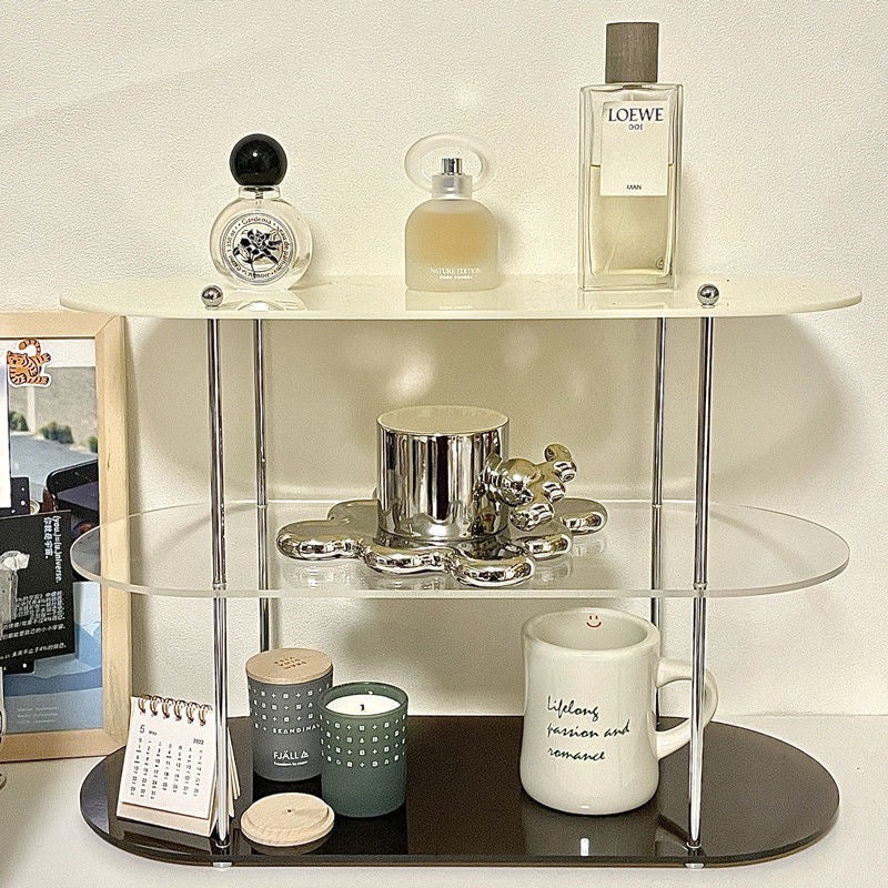 Acrylic Three-Tier Desktop Organizer with chrome supports, holding perfume, candles, and decor items