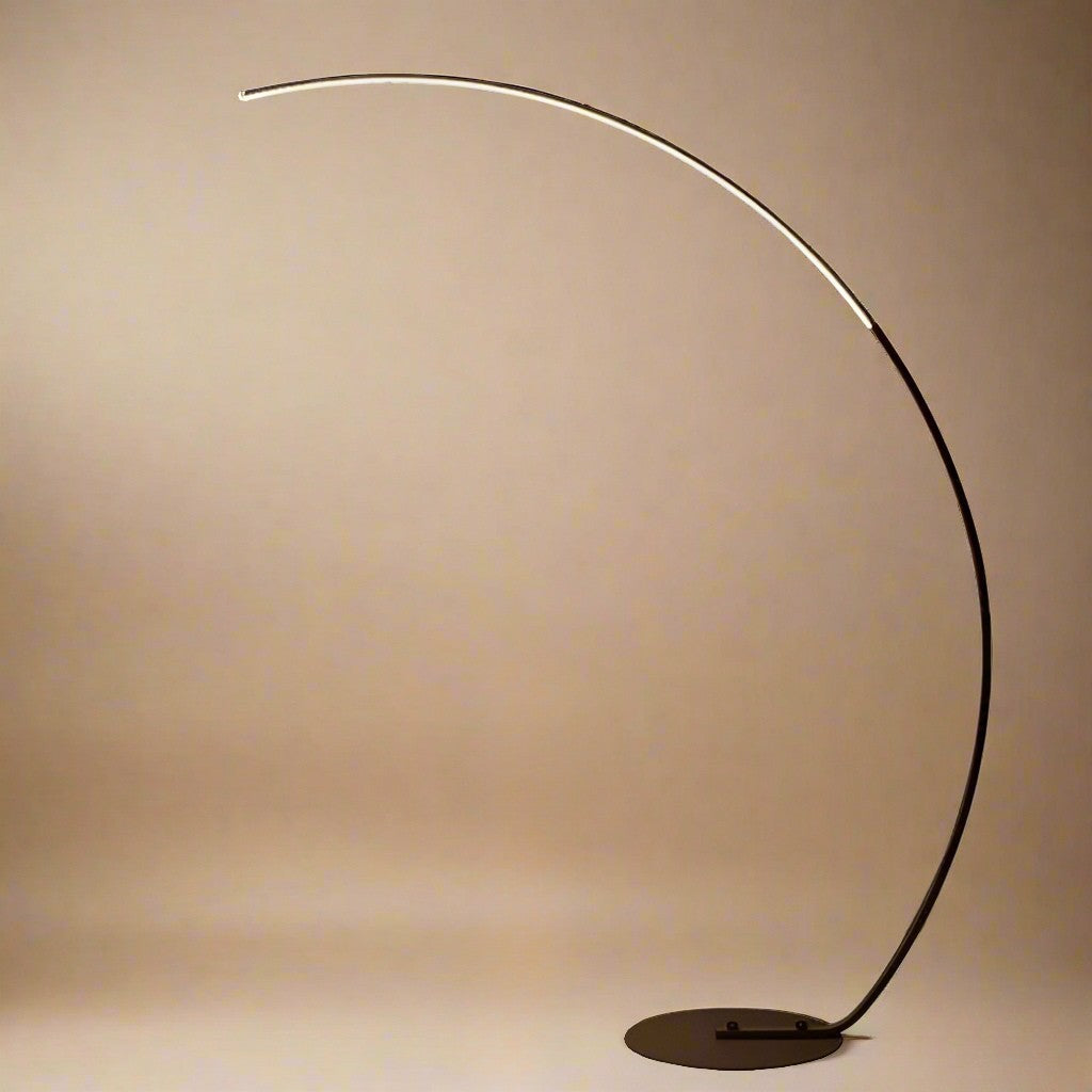 Arched Linear Floor Lamp with a slim curved frame and minimalist LED light, shown in a warm beige studio setting