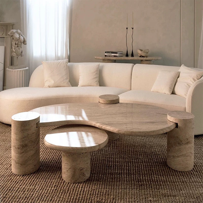 Ardea Travertine Coffee Table Set with layered stone tops and cylinder legs styled in a neutral living room with curved sofa