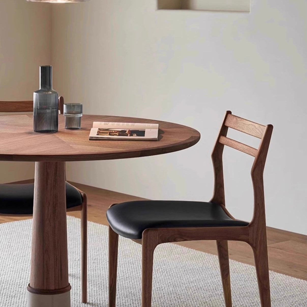Aspen Classic Dining Chair with black leather seat and curved solid wood frame beside a round dining table