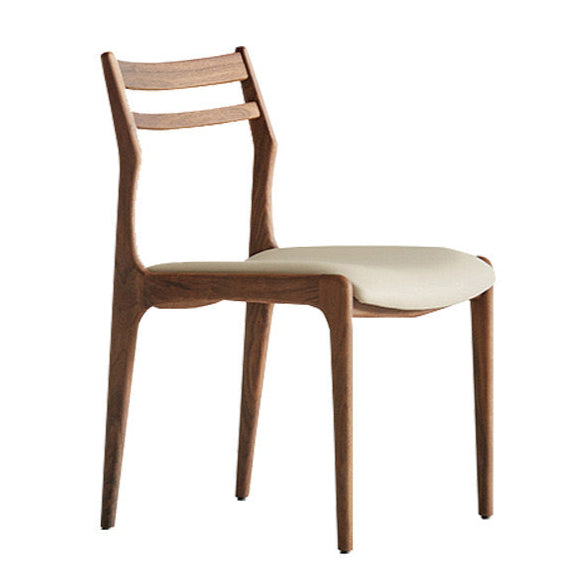 Aspen Classic Dining Chair with walnut wood frame and light upholstered seat in a minimalist studio setting