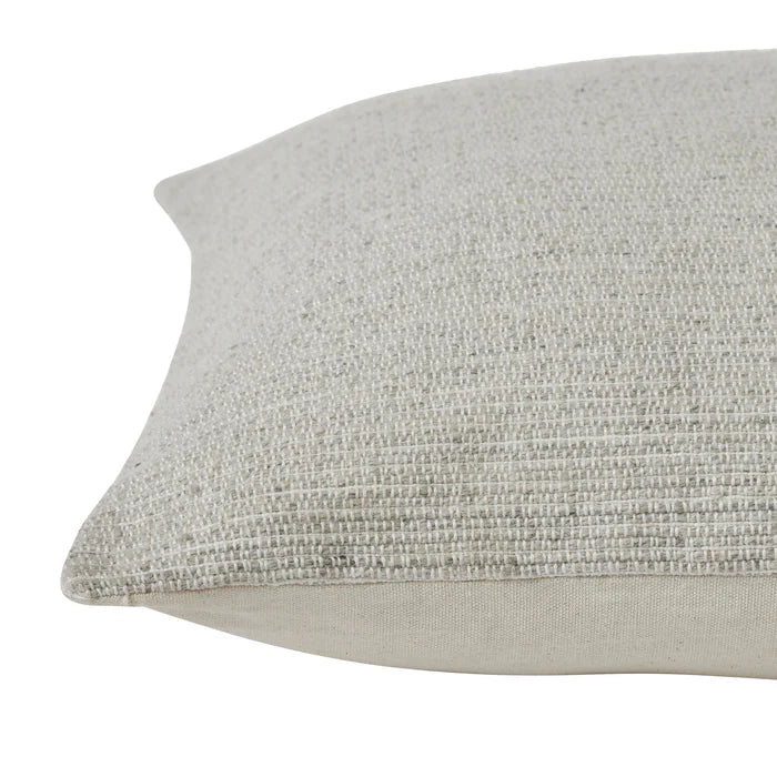Close-up of the corner on the beige Bennett throw pillow highlighting its textured fabric and solid piped edge.
