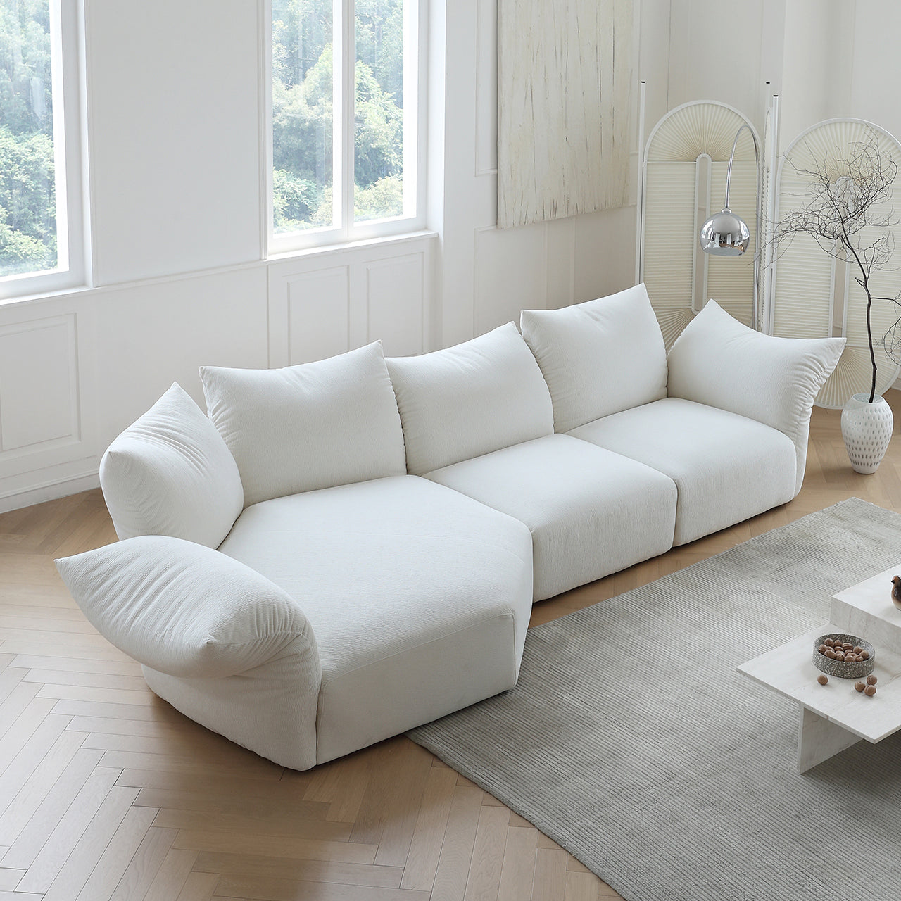 Blooming Embrace Modular Sofa in soft white fabric displayed in a bright studio setting with herringbone floor and modern decor