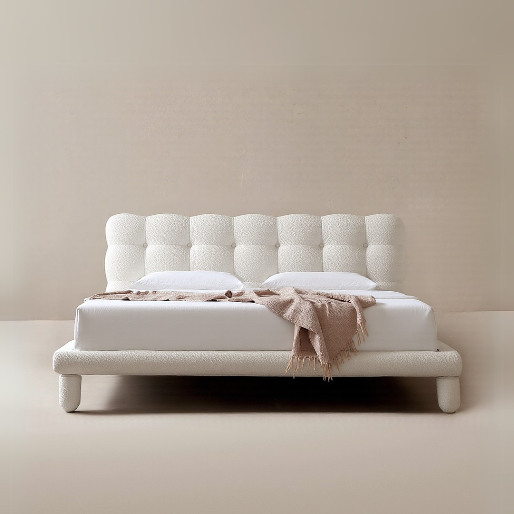 Bubbly Bliss Bed in white boucle fabric with rounded legs and tufted headboard styled in a minimal beige studio setting