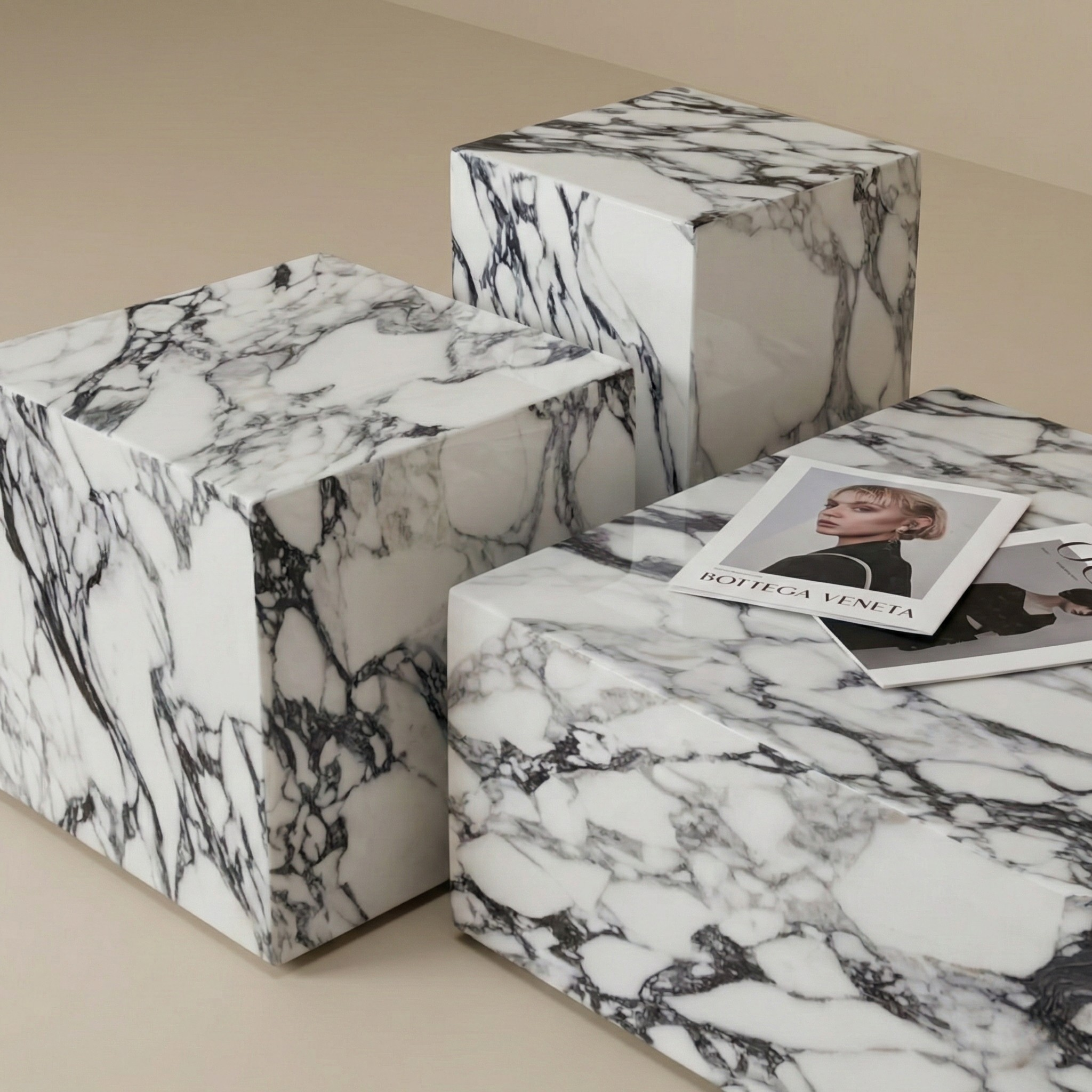Angled view of the geometric marble plinth table set showing the varying heights and solid block construction.
