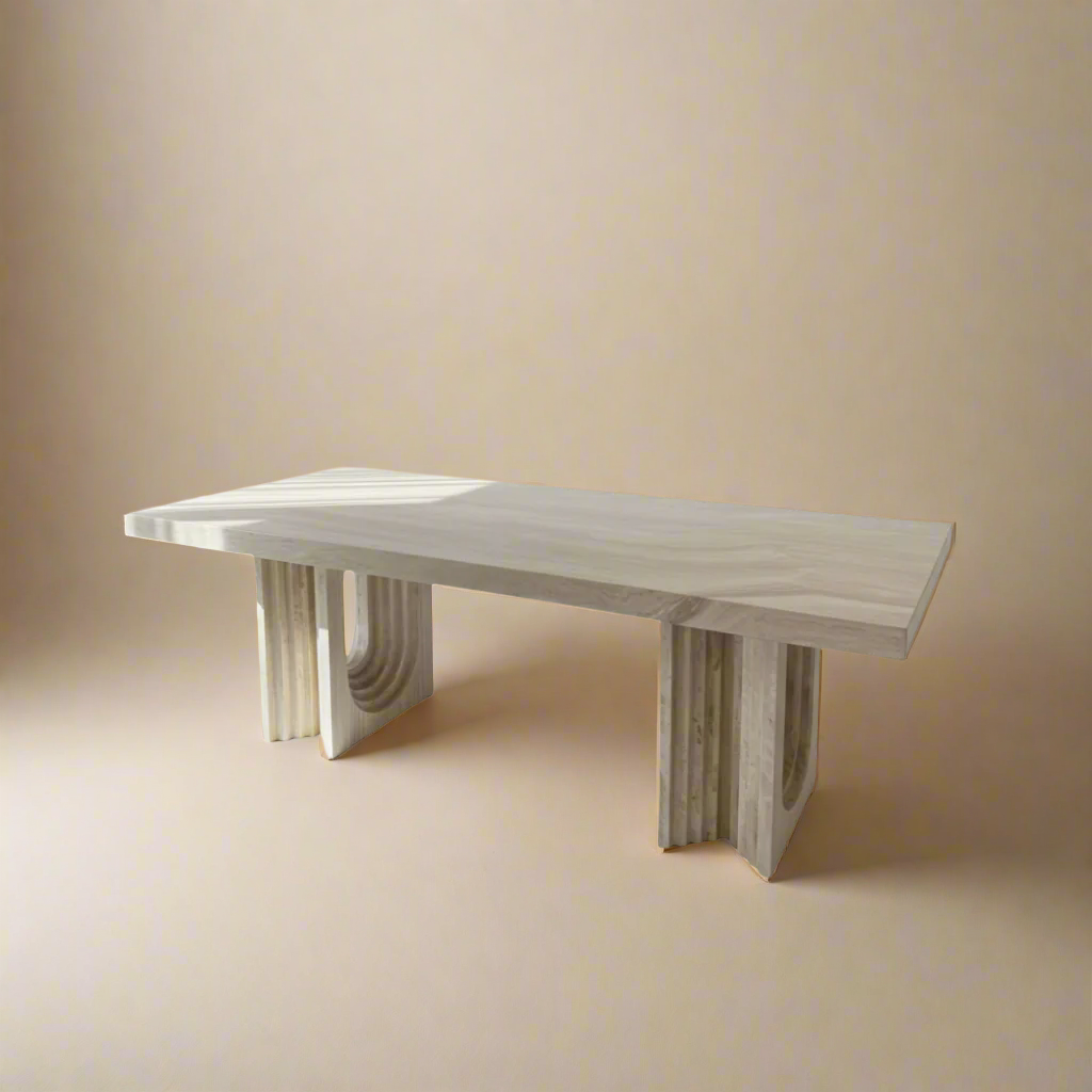 Caden Natural Travertine Dining Table with sculptural U-shaped bases and a smooth stone top in a neutral studio setting