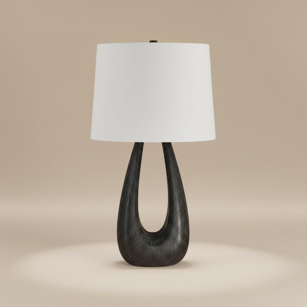 Calla Table Lamp with sculpted black wood base and white fabric shade in a neutral studio setting