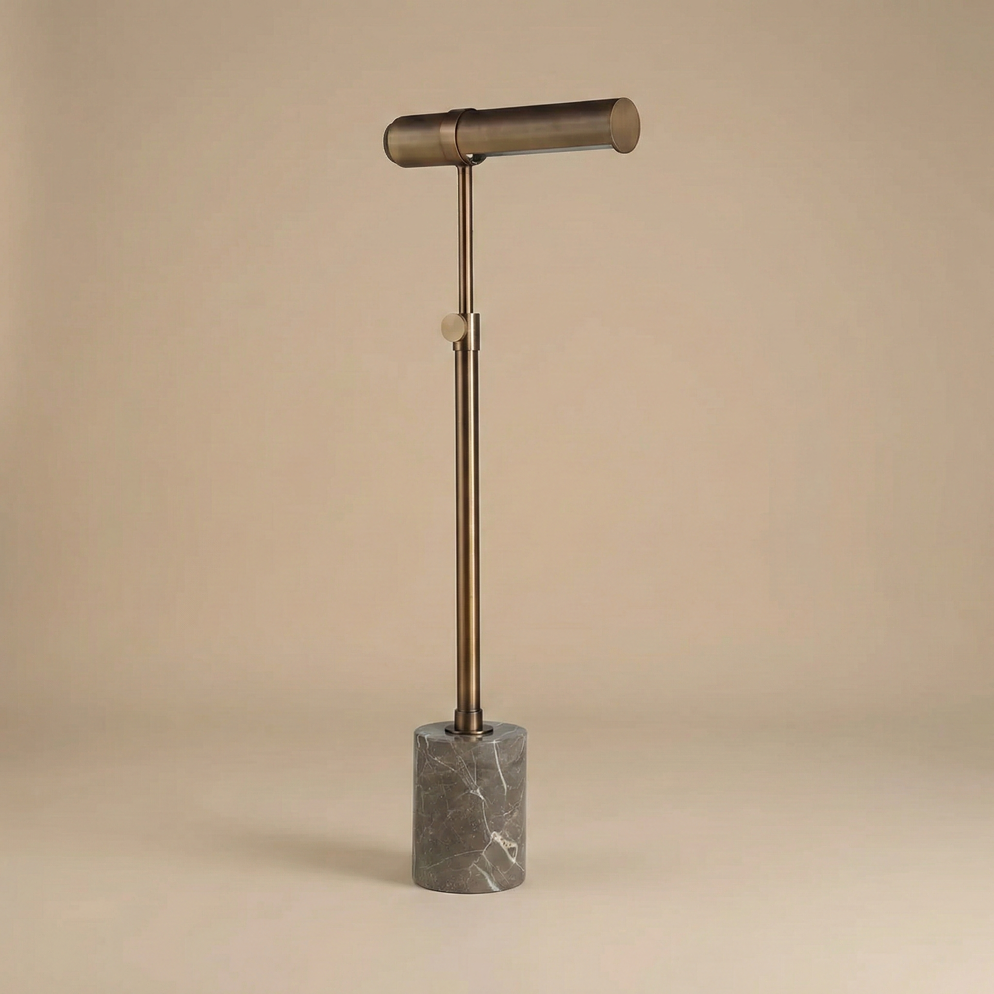 Calloway adjustable floor lamp featuring an antique brass finish, cylindrical metal shade, and grey marble base.