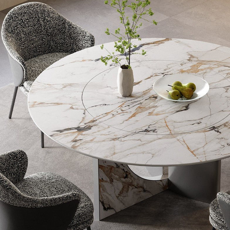 Celesti Elegance round dining table with marble-patterned sintered stone top and stainless steel base, decorated with vase and fruit bowl