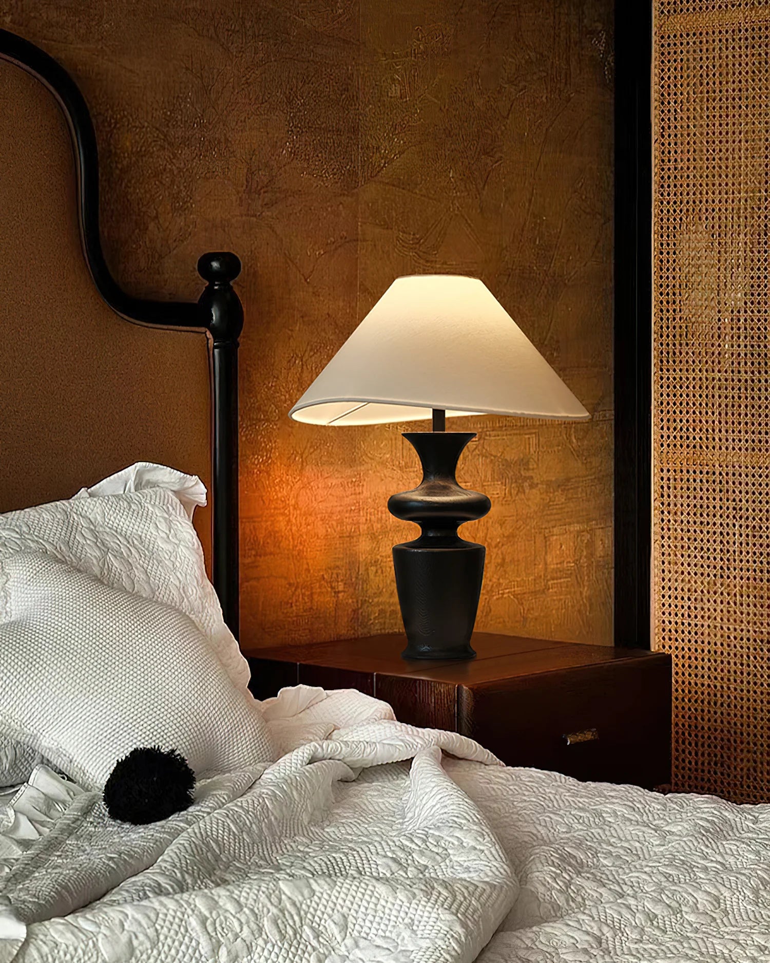 Contour Table Lamp with black sculpted base and white shade on bedside table in warm cozy bedroom
