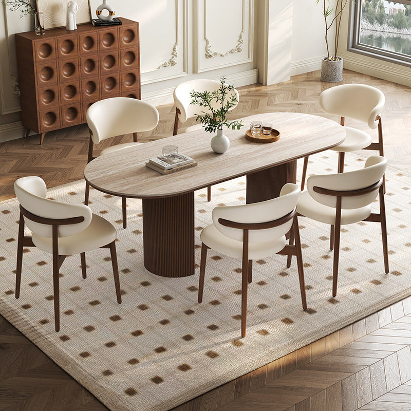 Crescent Grove Dining Table styled in an elegant dining room with cream chairs and decorative accents on top