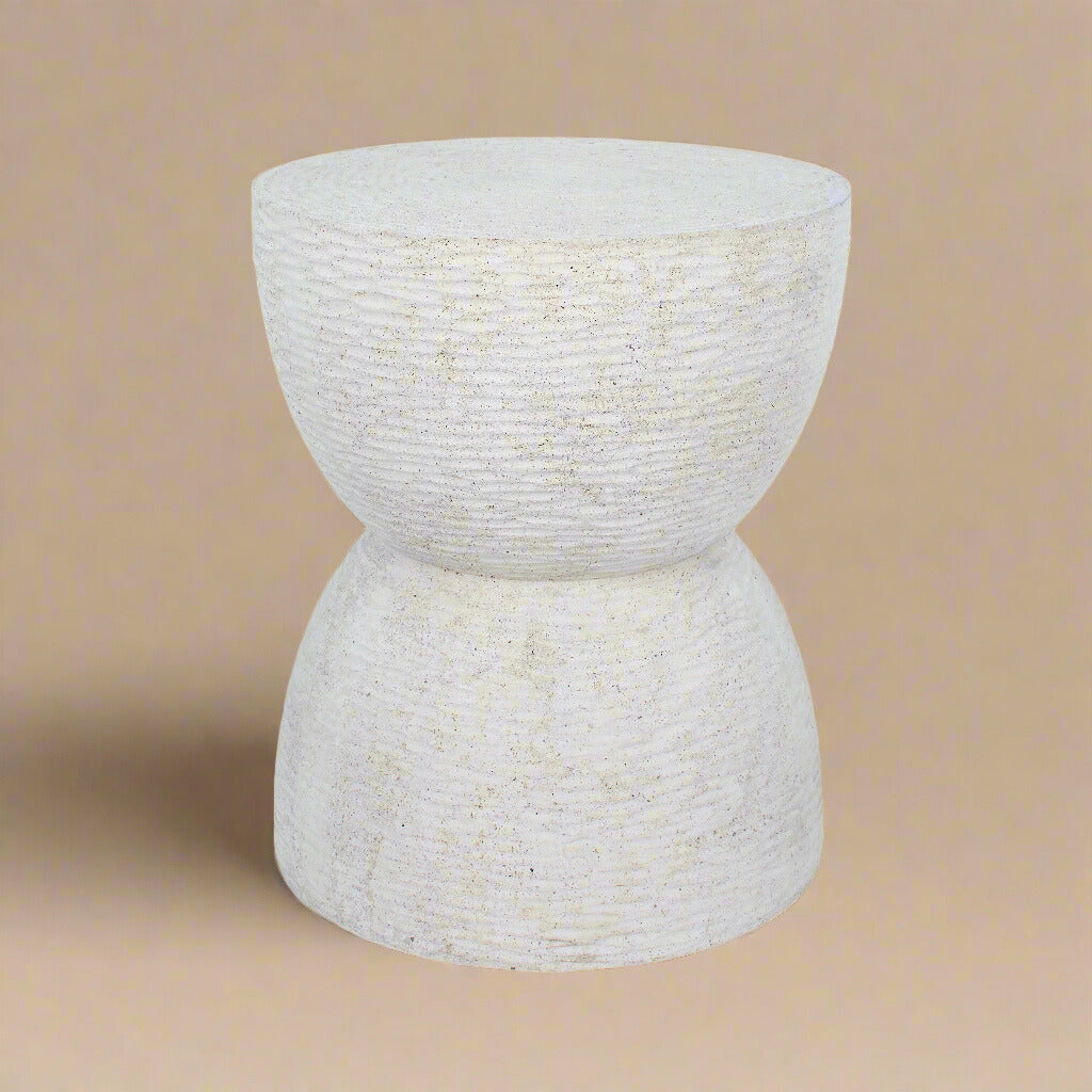 Dune side table featuring a sculptural hourglass silhouette and textured white concrete finish.
