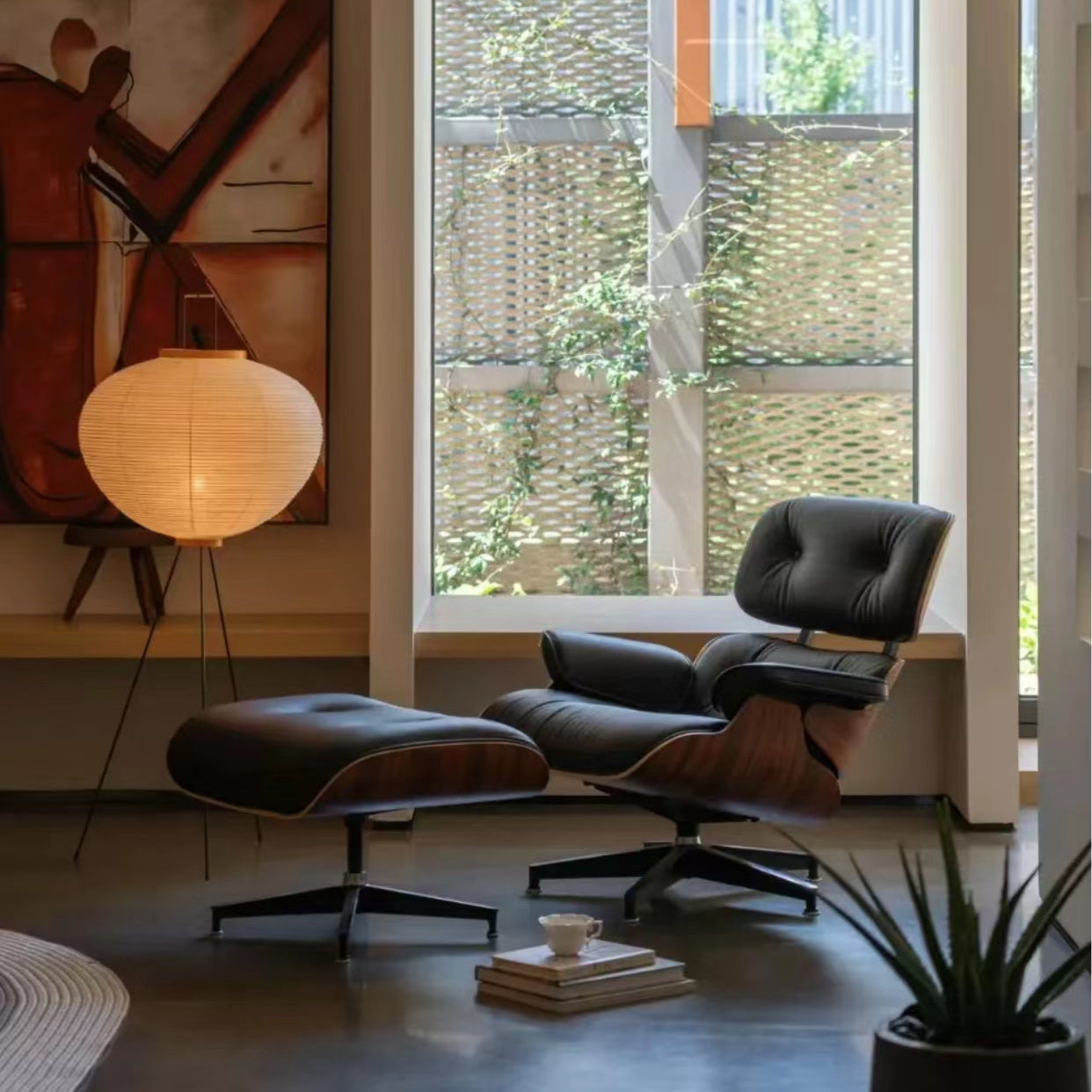 Eames Lounge Chair and ottoman in black leather and walnut wood placed by window with warm lighting and floor lamp
