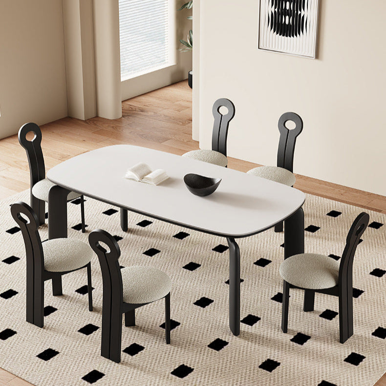 Top view of Eclipse Elegance dining table with sintered stone top and black curved legs styled with boucle dining chairs