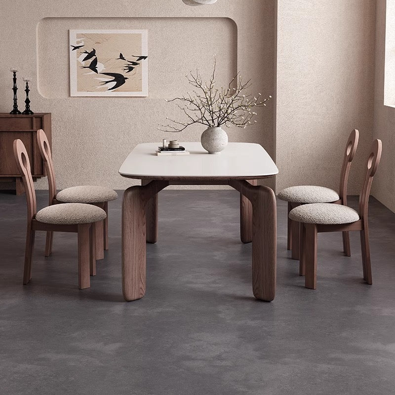 Front view of Eclipse Elegance dining table with sintered stone top and walnut curved legs styled with boucle dining chairs