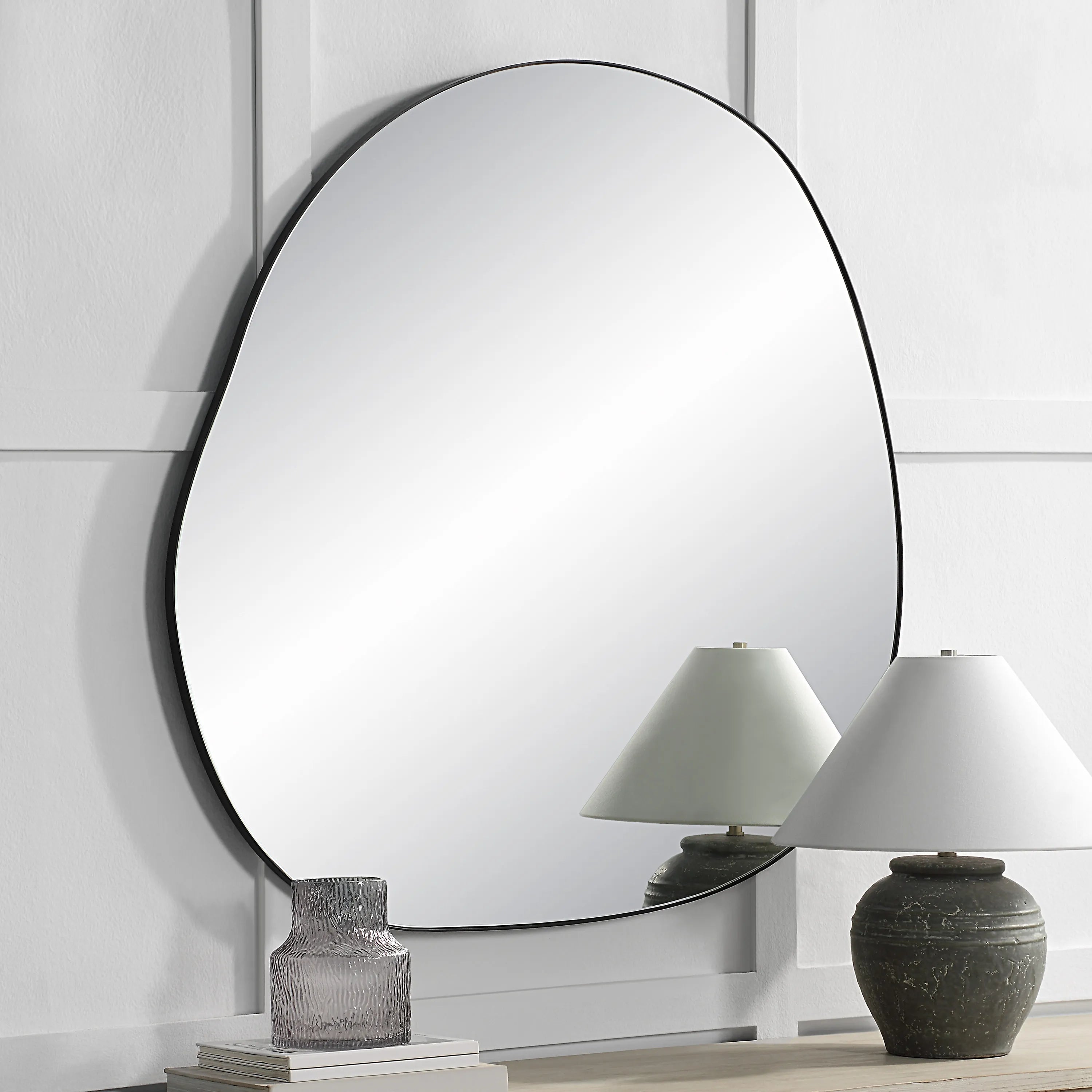 Eclipse Wall Mirror displayed in a modern room with decor and two table lamps