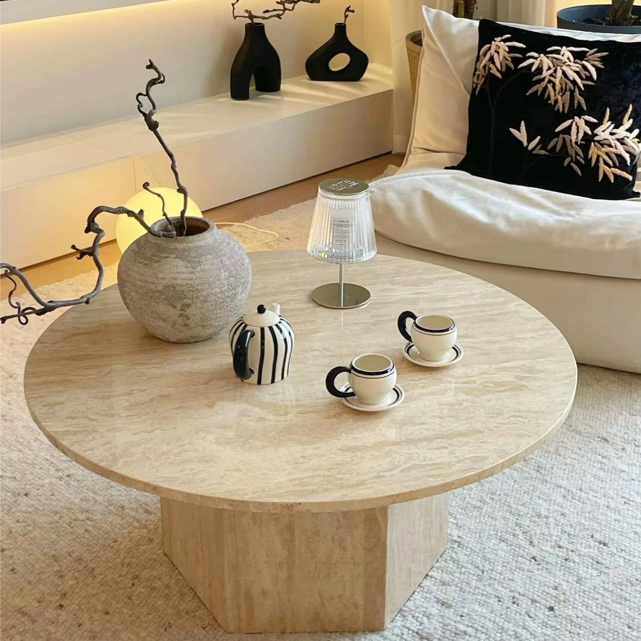 Harmony Travertine Coffee Table styled in a cozy living room with ceramic decor, tea set, and warm ambient lighting