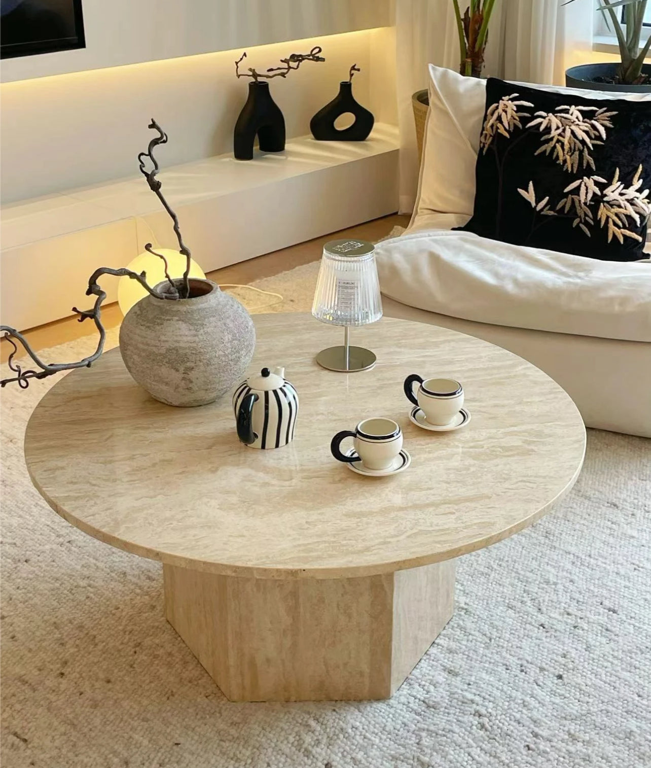 Harmony Travertine Coffee Table styled in a cozy living room with ceramic decor, tea set, and warm ambient lighting
