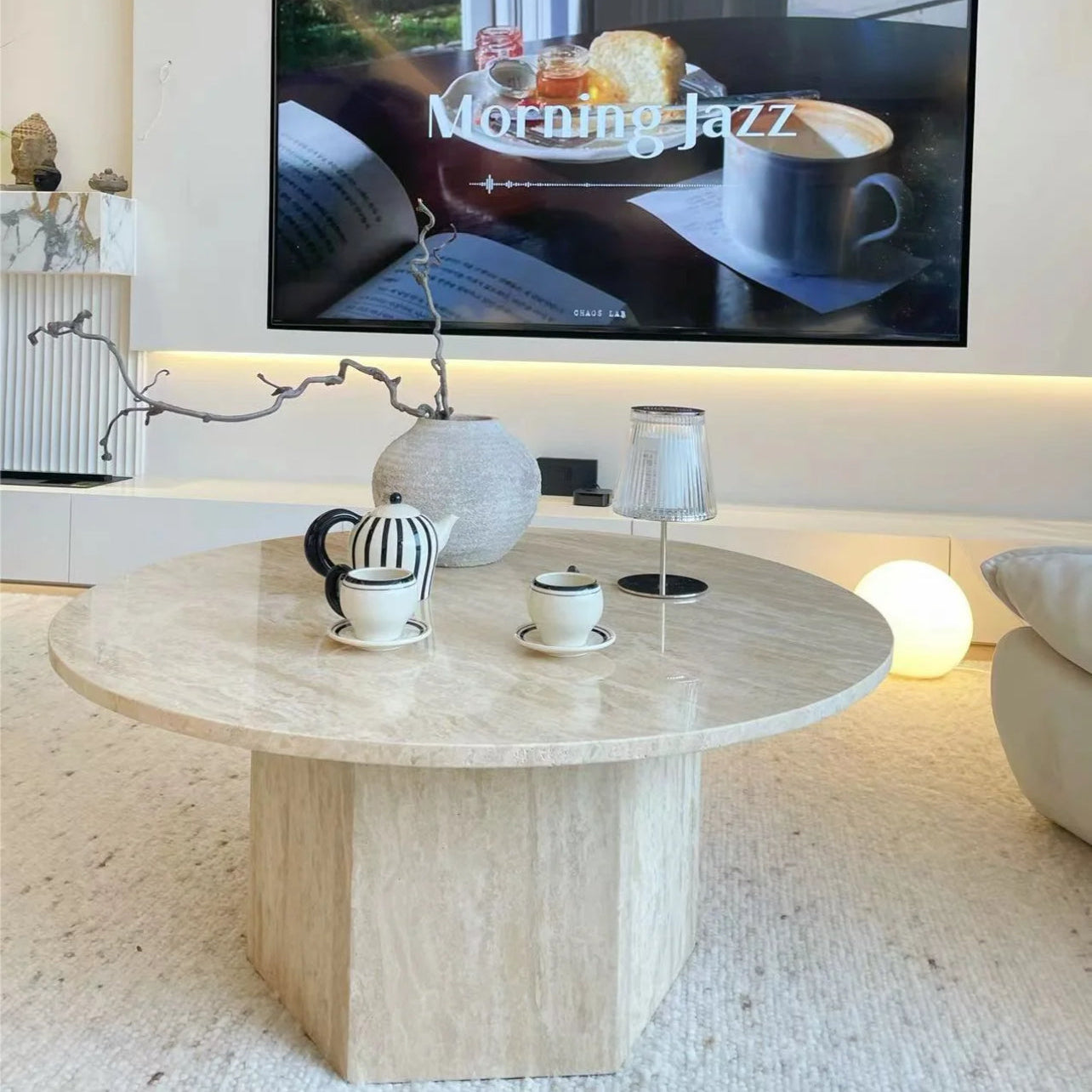 Harmony Travertine Coffee Table styled with striped teapot and cups in a cozy living room playing Morning Jazz on TV