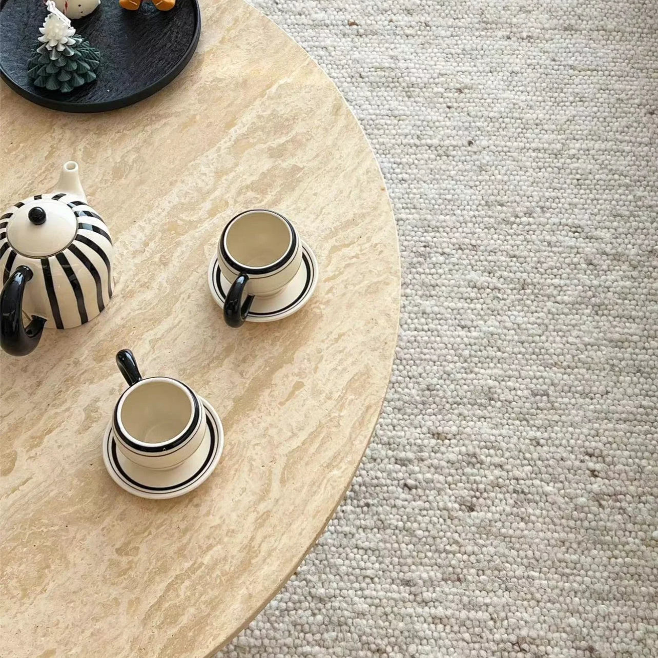 Harmony Travertine Coffee Table top view with striped teapot and matching cups on neutral textured rug
