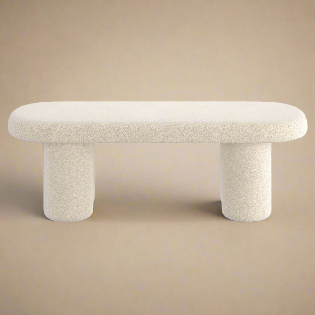 A beige upholstered bench with bouclé fabric and cylindrical legs, with a minimalist contemporary design.