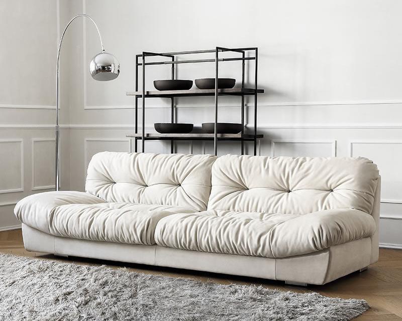 Italian-style Cloud Sofa in cream ultra suede upholstery with tufted cushions, styled in a modern living room with rug and floor lamp