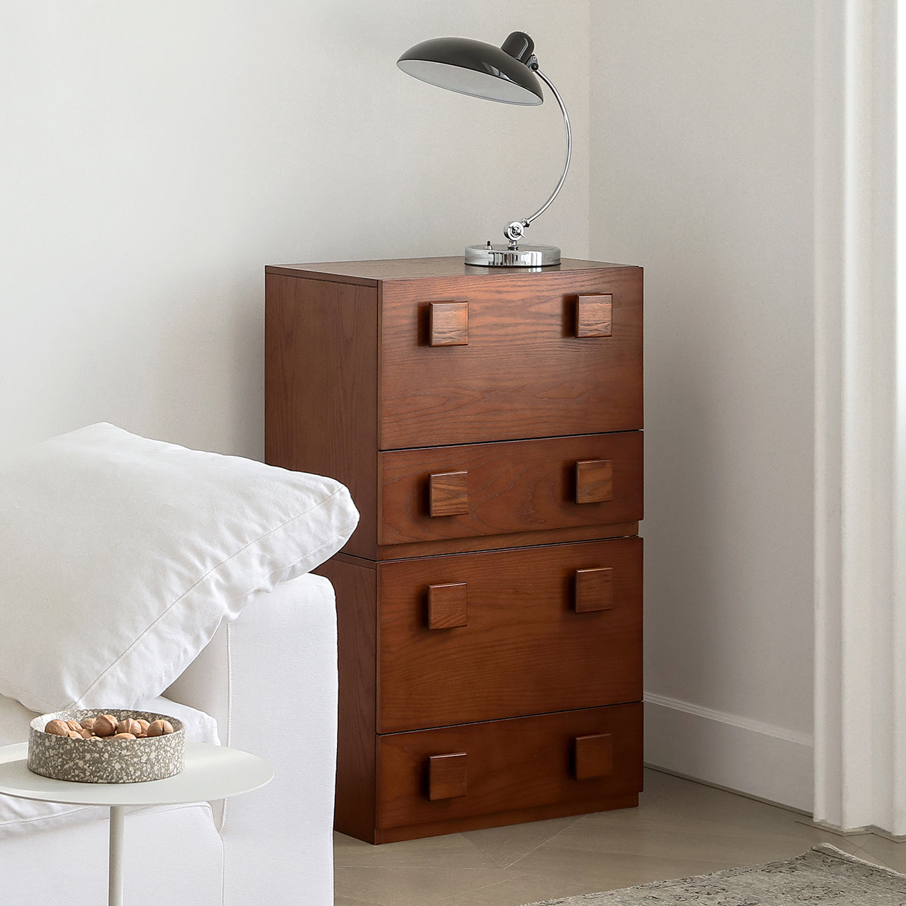 Jasper Modular Sideboard stacked with three wood drawer units and square handles, styled beside a sofa in a modern living room.