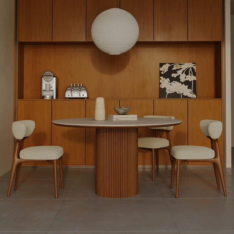 Lucia Dining Table with round sintered stone top and fluted wood base, paired with beige upholstered chairs in a modern dining space
