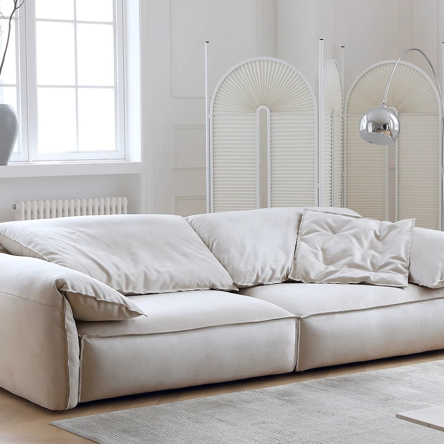 Luxury Elephant Ear Sofa in cream ultra suede with plush cushions and relaxed silhouette in a bright modern living room