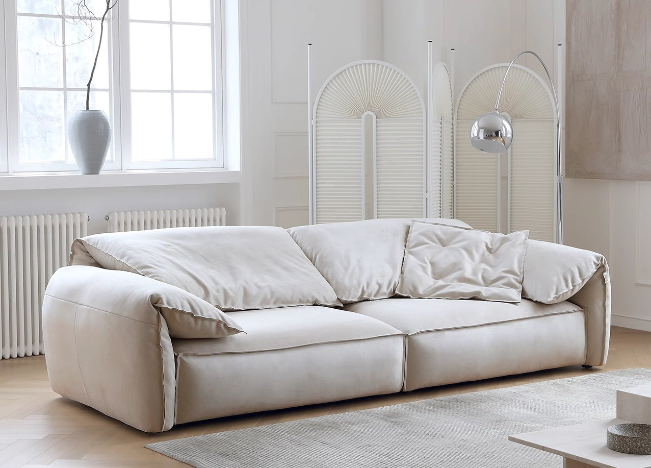 Luxury Elephant Ear Sofa in cream ultra suede with plush cushions and relaxed silhouette in a bright modern living room