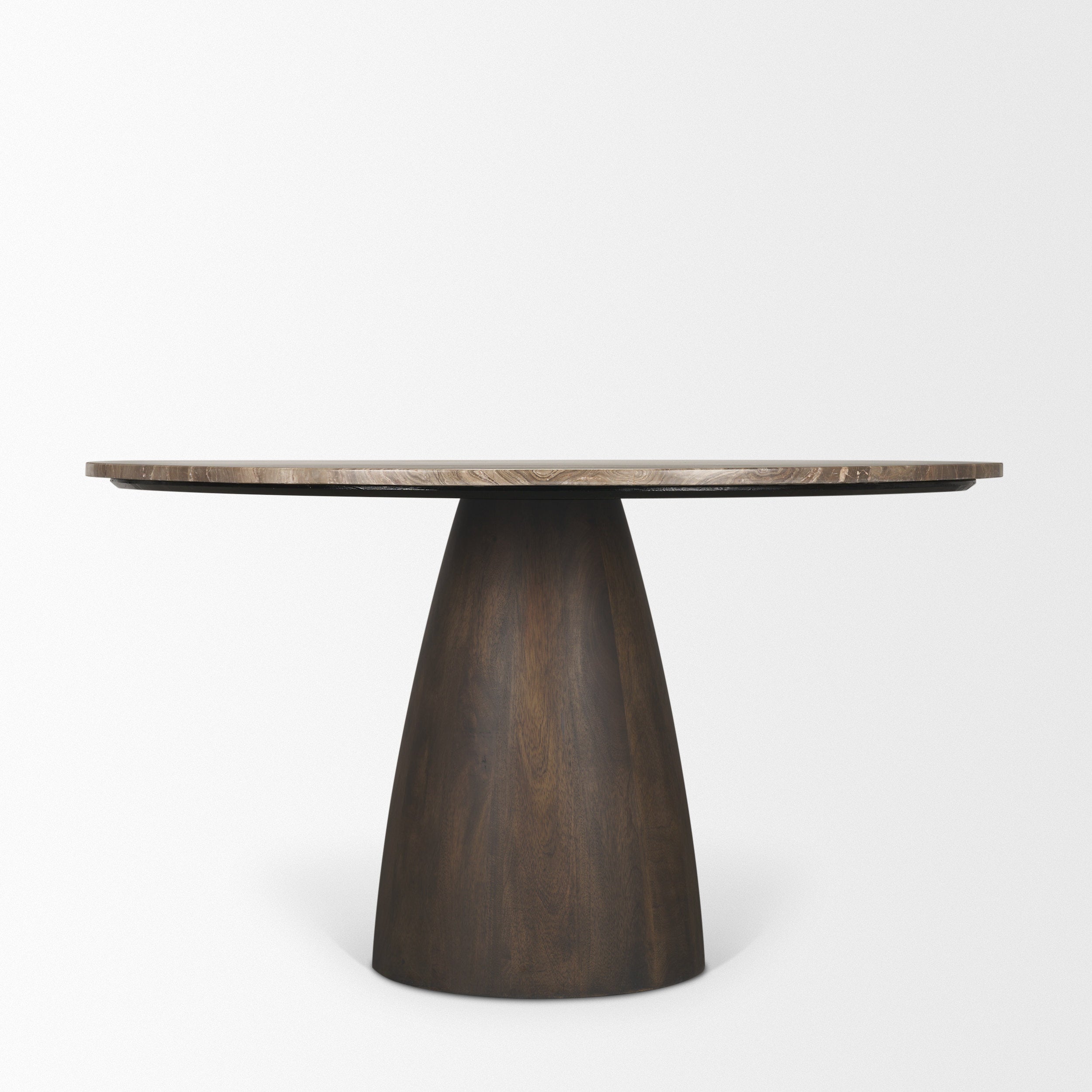 Angled studio view of the Mateo round marble dining table showcasing its sculptural silhouette and organic materials.