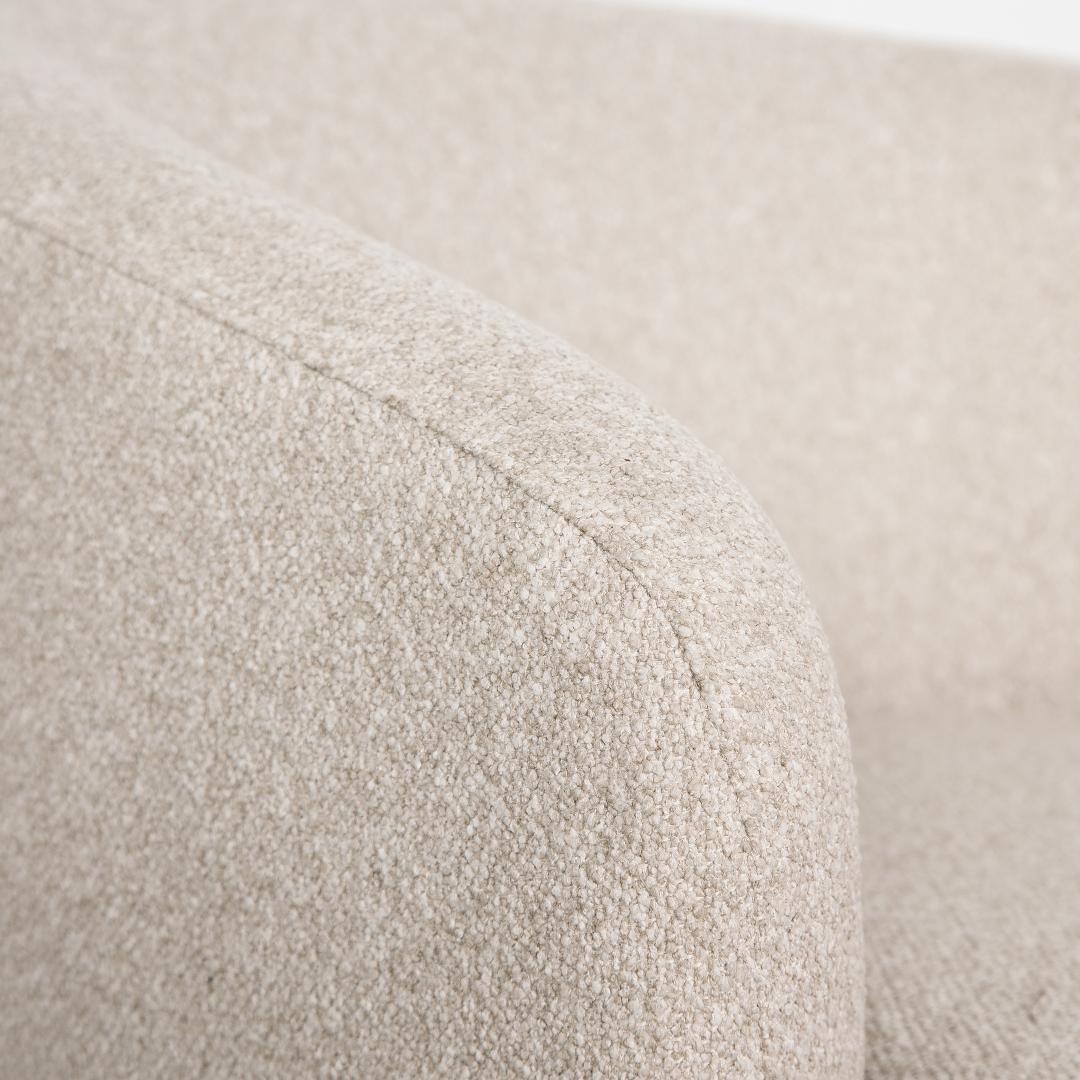 Close-up shot of the Milo chair armrest showcasing the high-quality upholstery work on the textured bouclé.