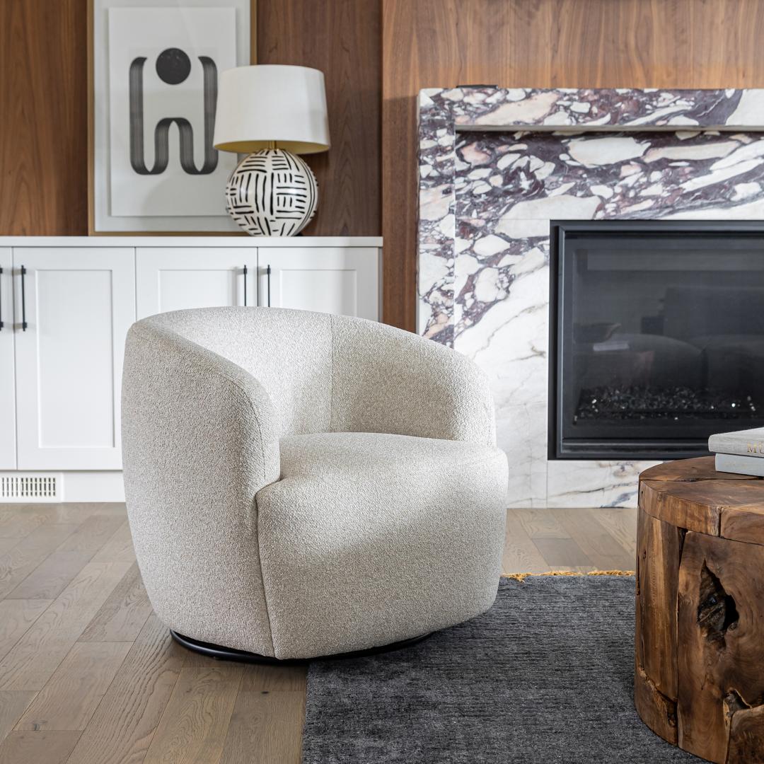 The Milo swivel chair styled in a luxury living space featuring a marble fireplace and rich walnut wall paneling.