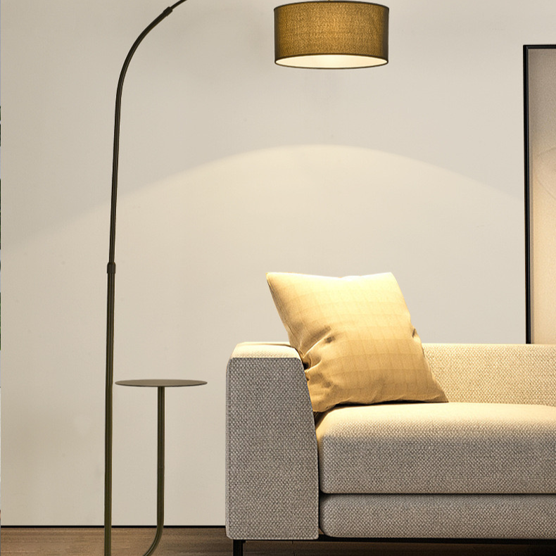 Noir Tray Curve Lamp with built-in side tray placed beside a modern beige sofa in a warm living room setting