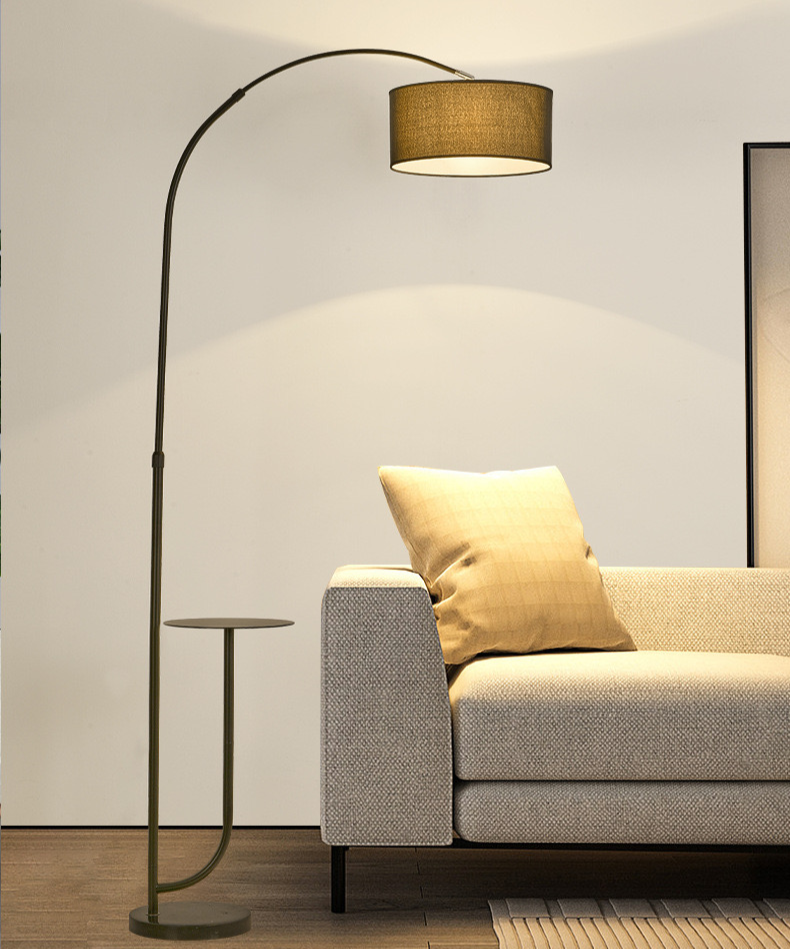 Noir Tray Curve Lamp with built-in side tray placed beside a modern beige sofa in a warm living room setting