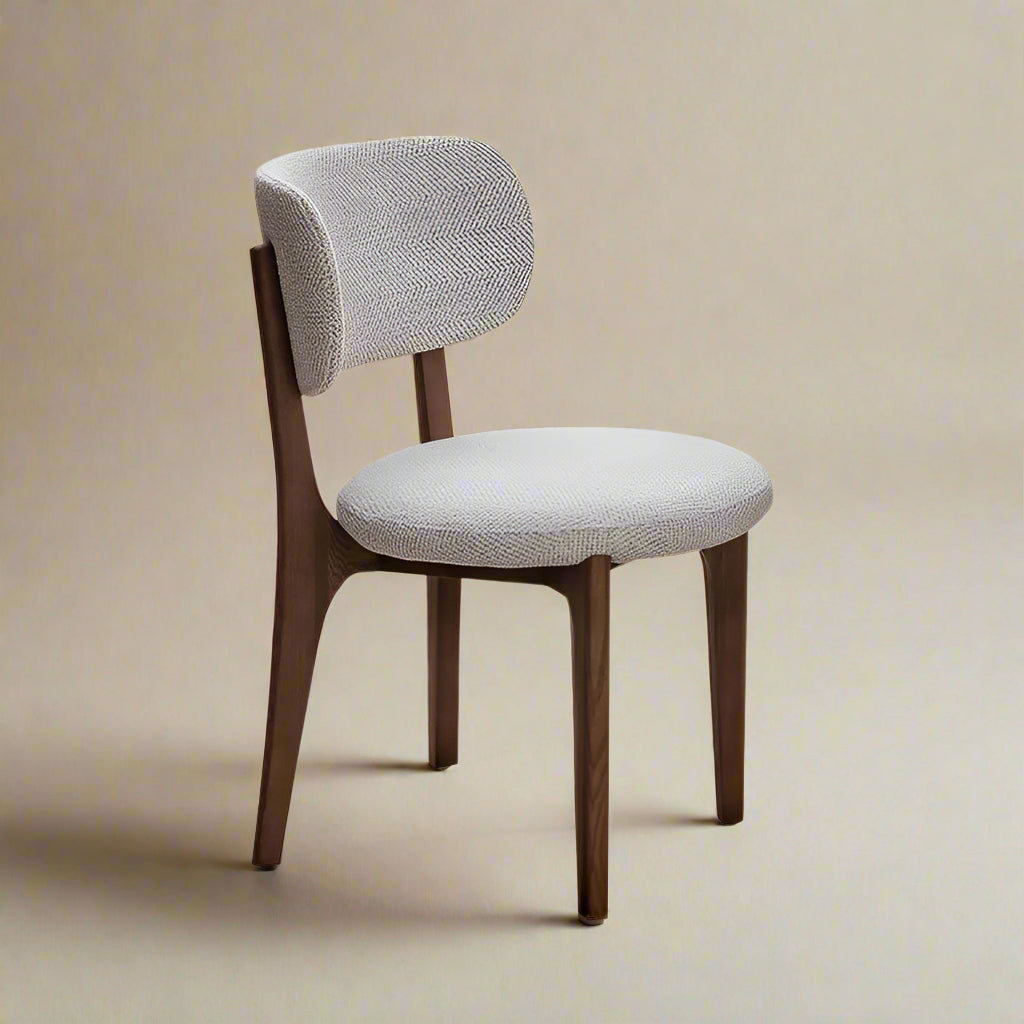 Nolan Linen Ash Wood Dining Chair with curved backrest and light textured upholstery in a neutral studio setting
