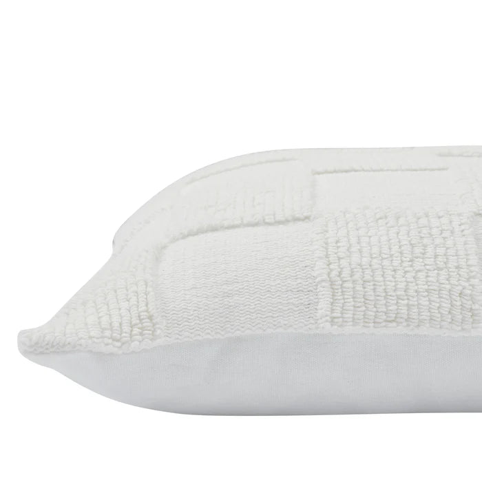 Close-up of the corner and thick knitted checkerboard fabric on the cream Piper throw pillow.