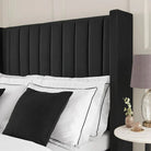 Close-up of Plush Velvet Storage Bed in black velvet showing vertical panel headboard with white bedding and black accent pillows