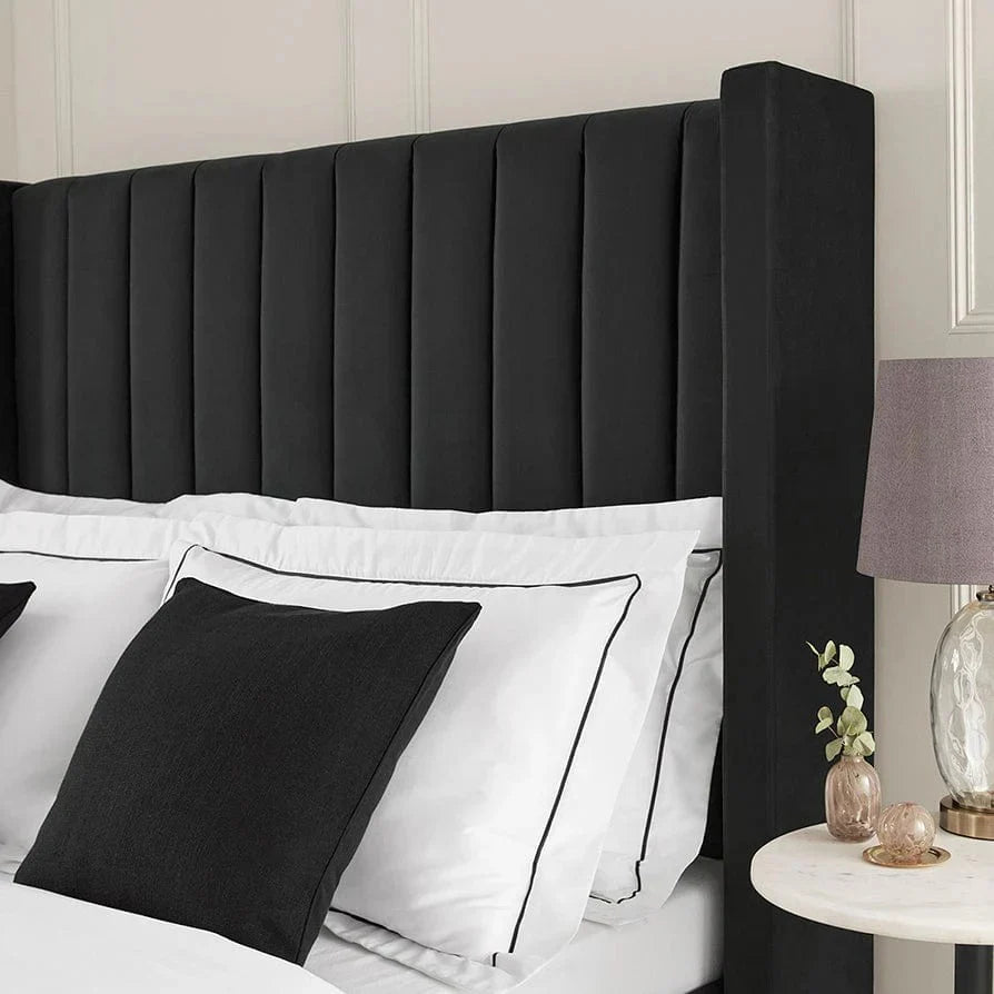 Close-up of Plush Velvet Storage Bed in black velvet showing vertical panel headboard with white bedding and black accent pillows