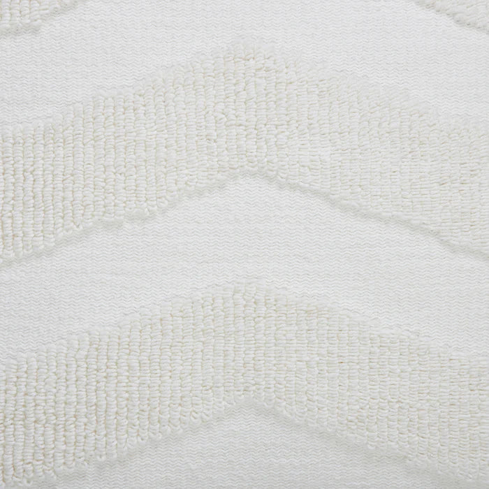 Macro close-up of the raised tufted chevron pattern and flat woven cream base on the Seraphina knitted pillow.