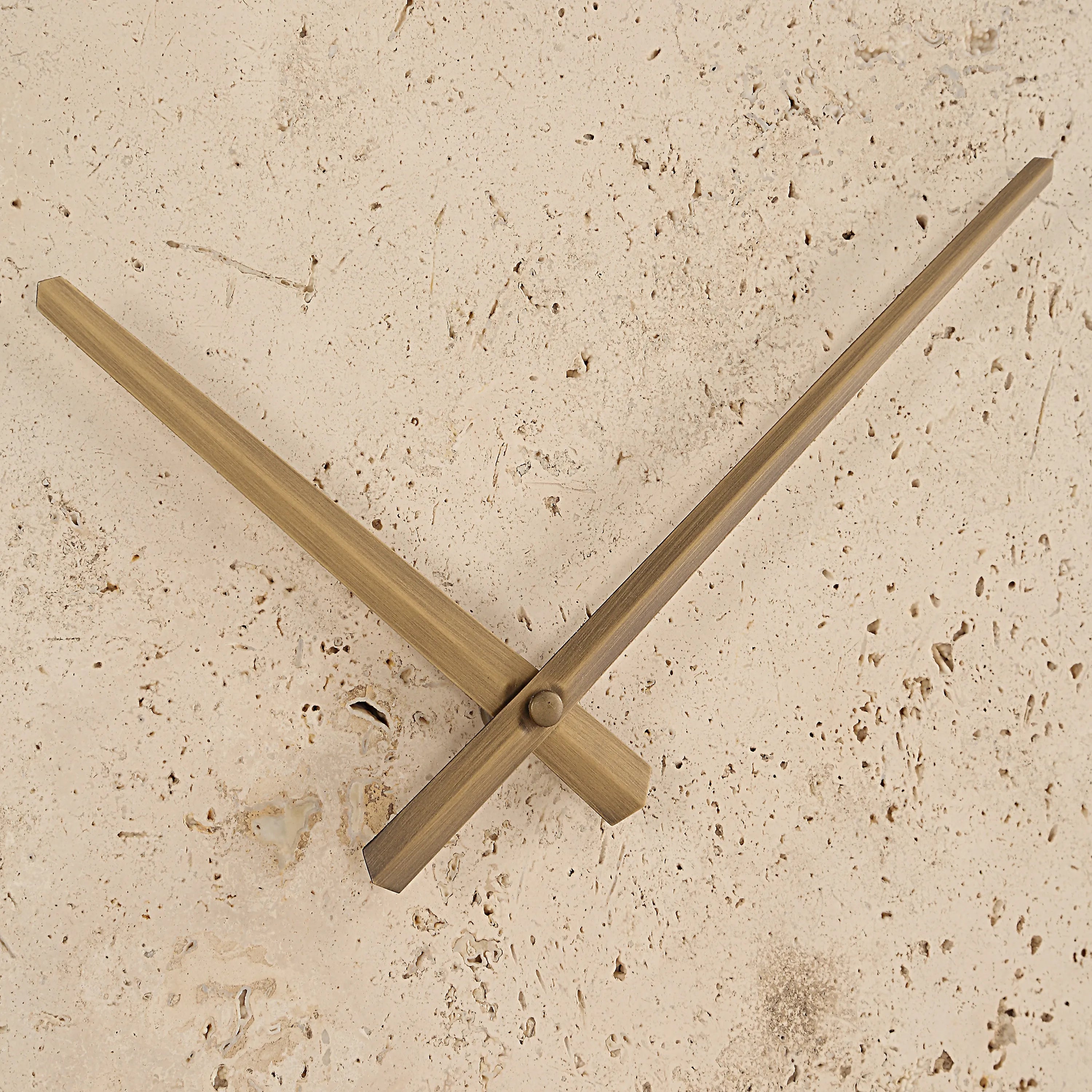 Close-up of Solea Travertine Wall Clock showing brass hands and natural stone texture detail