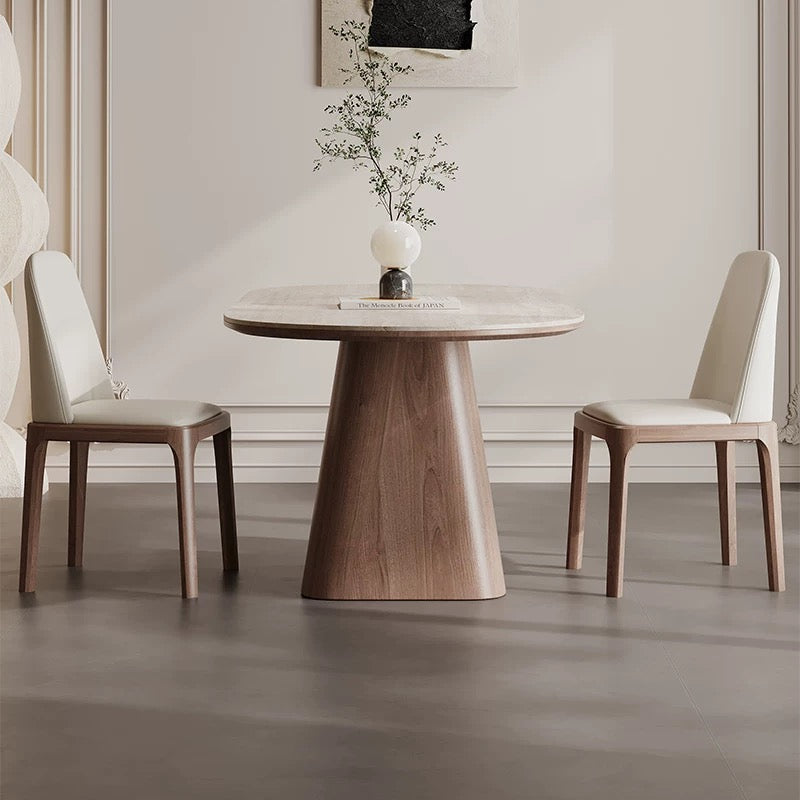 side view of Sorella pedestal dining table with sintered stone top and solid wood base between two cream chairs
