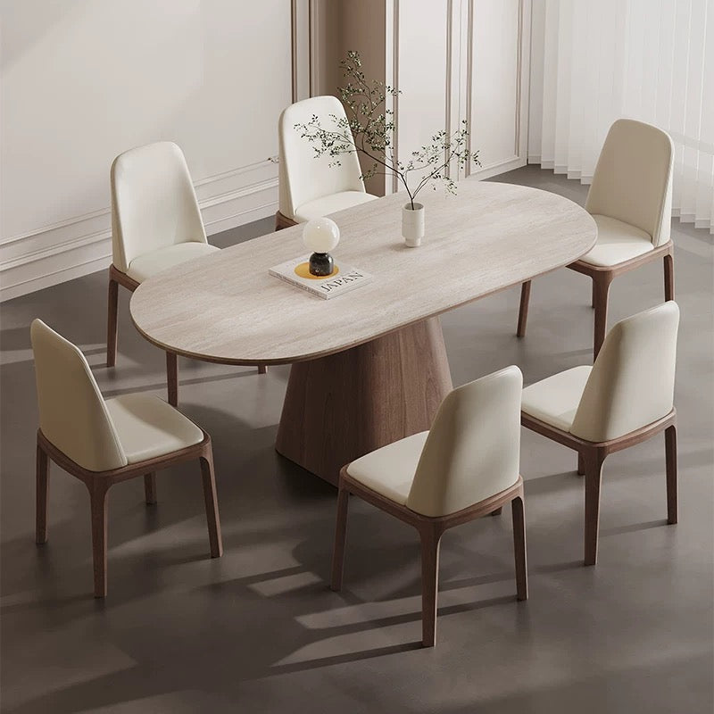 Angled view of Sorella pedestal dining table with sintered stone top and solid wood base surrounded by cream chairs