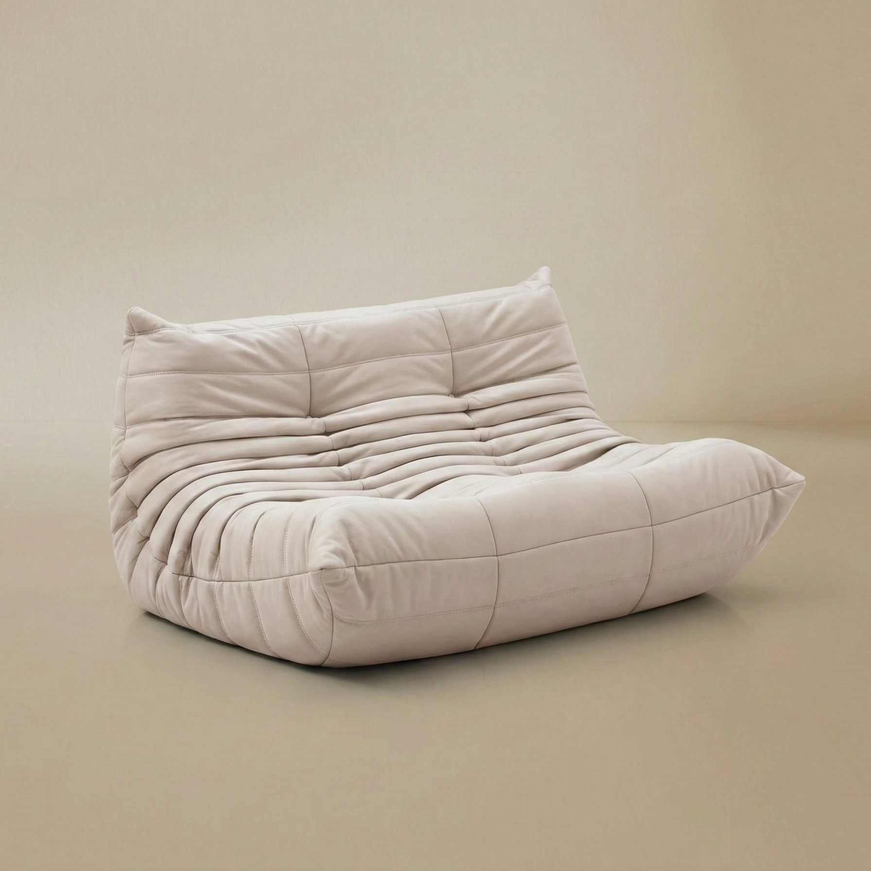 Angled view of the TOGO Lounger floor sofa showing the ergonomic curved shape and plush upholstery