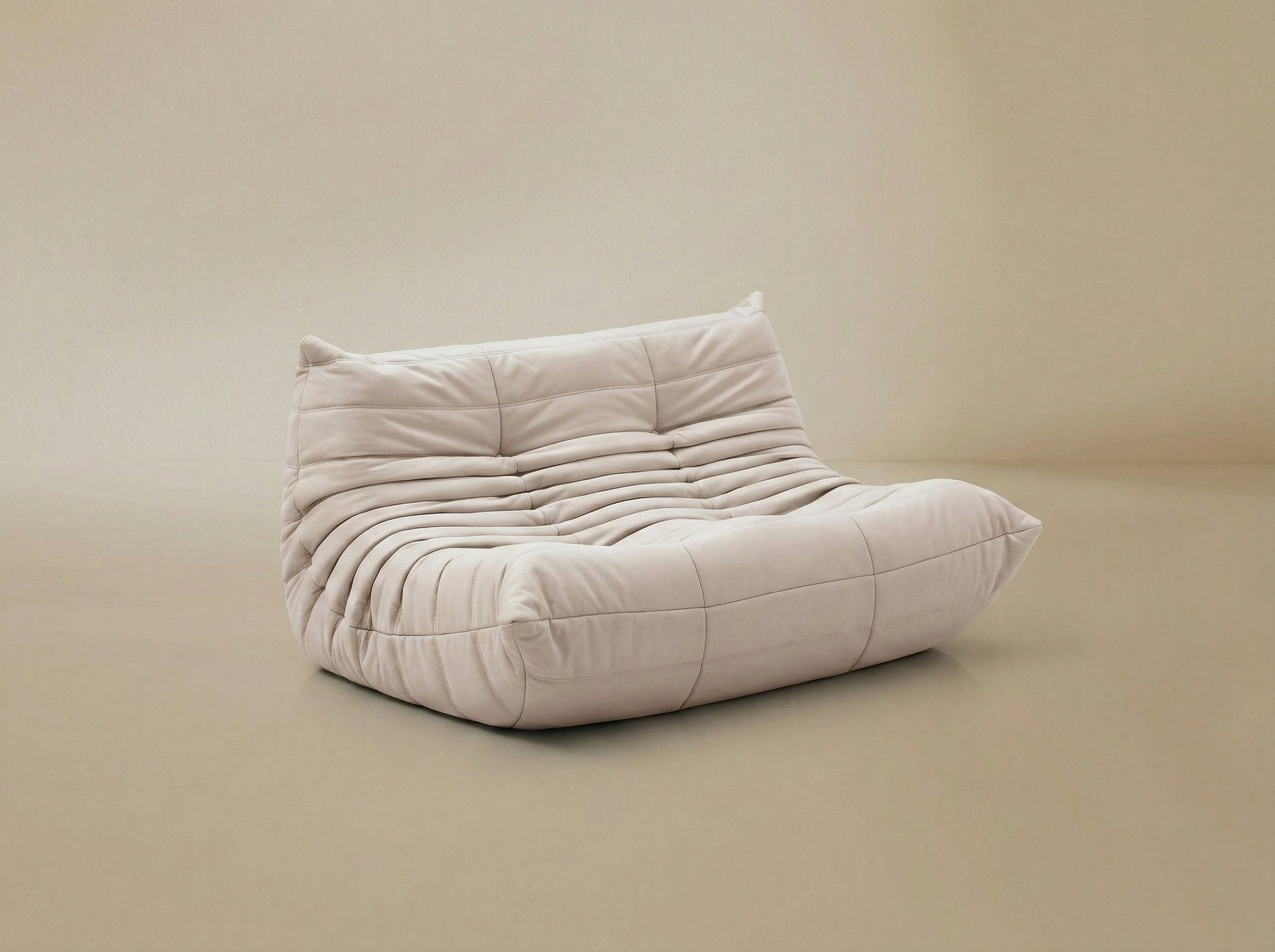 Angled view of the TOGO Lounger floor sofa showing the ergonomic curved shape and plush upholstery