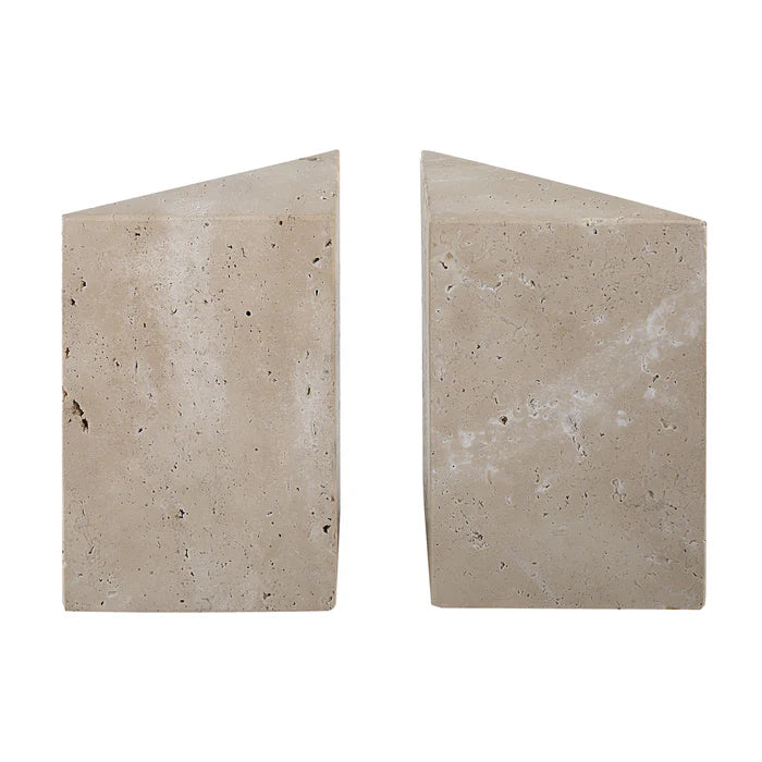 Side view of the travertine bookends showing the solid triangular block shape and natural beige stone texture.