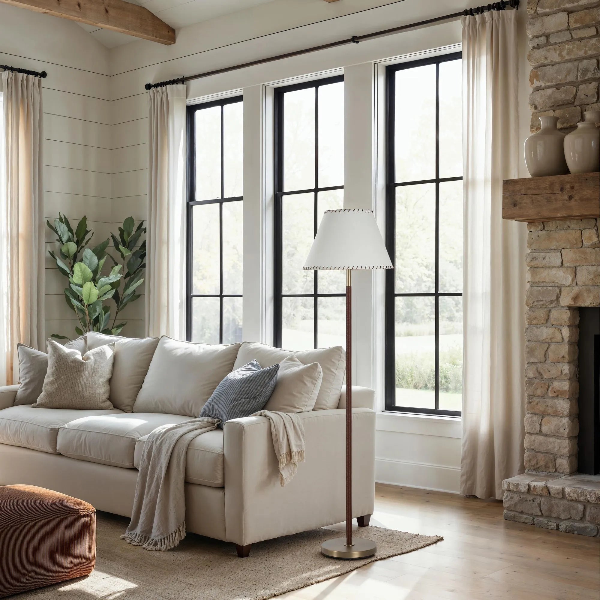 Valen floor lamp styled in a bright living room with high ceilings, standing next to a beige sofa.